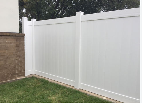 Clean white vinyl fence after professional pressure cleaning service in South Florida
